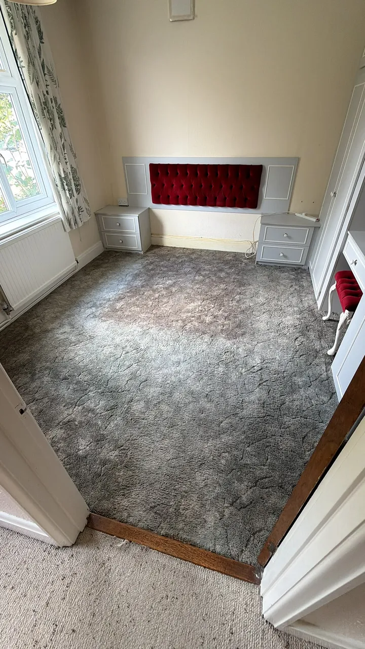 Bedroom after bed removal, with a red headboard, bedside units and wardrobes remaining