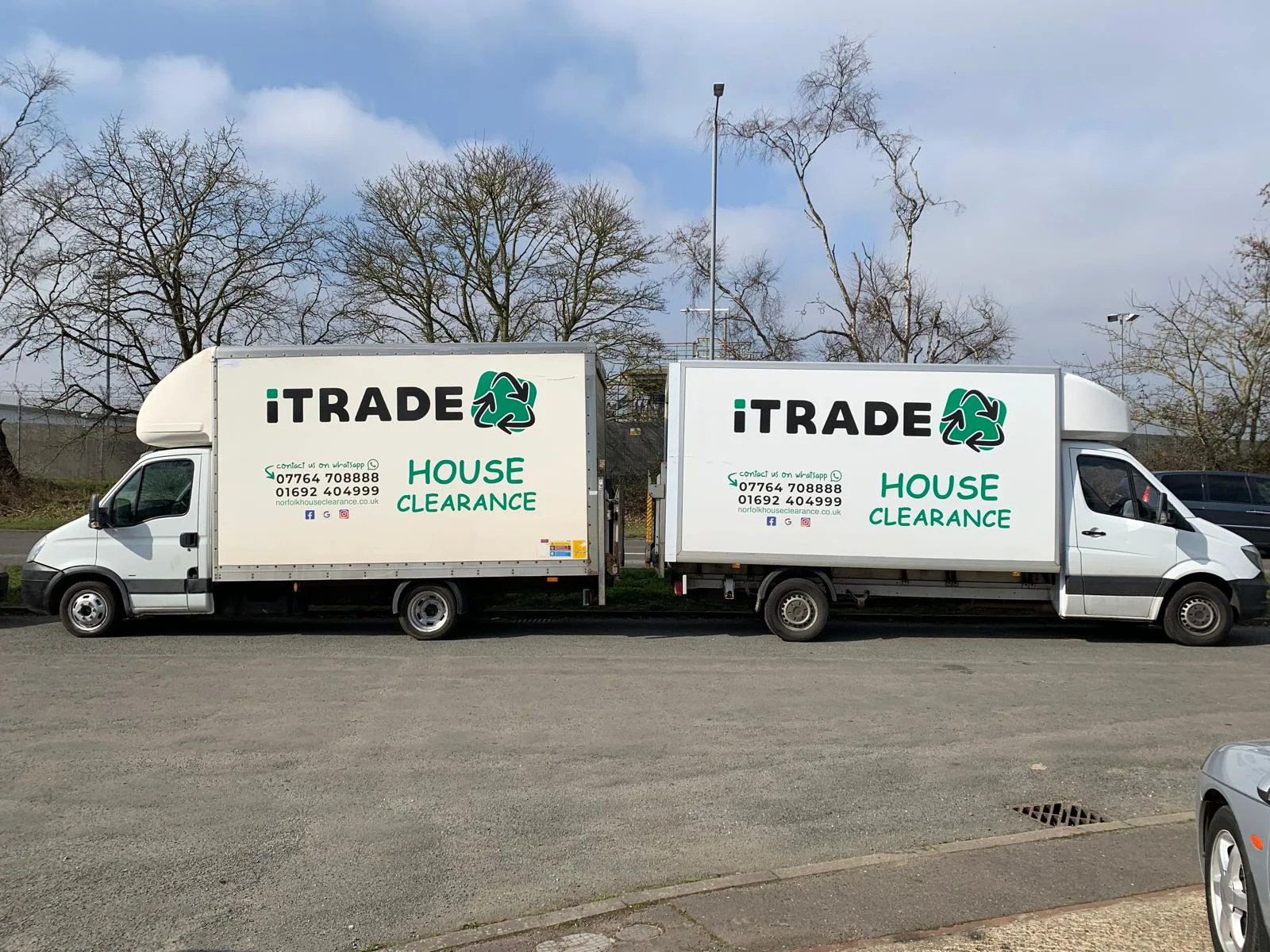 Two iTrade-branded house-clearance vehicles parked side by side