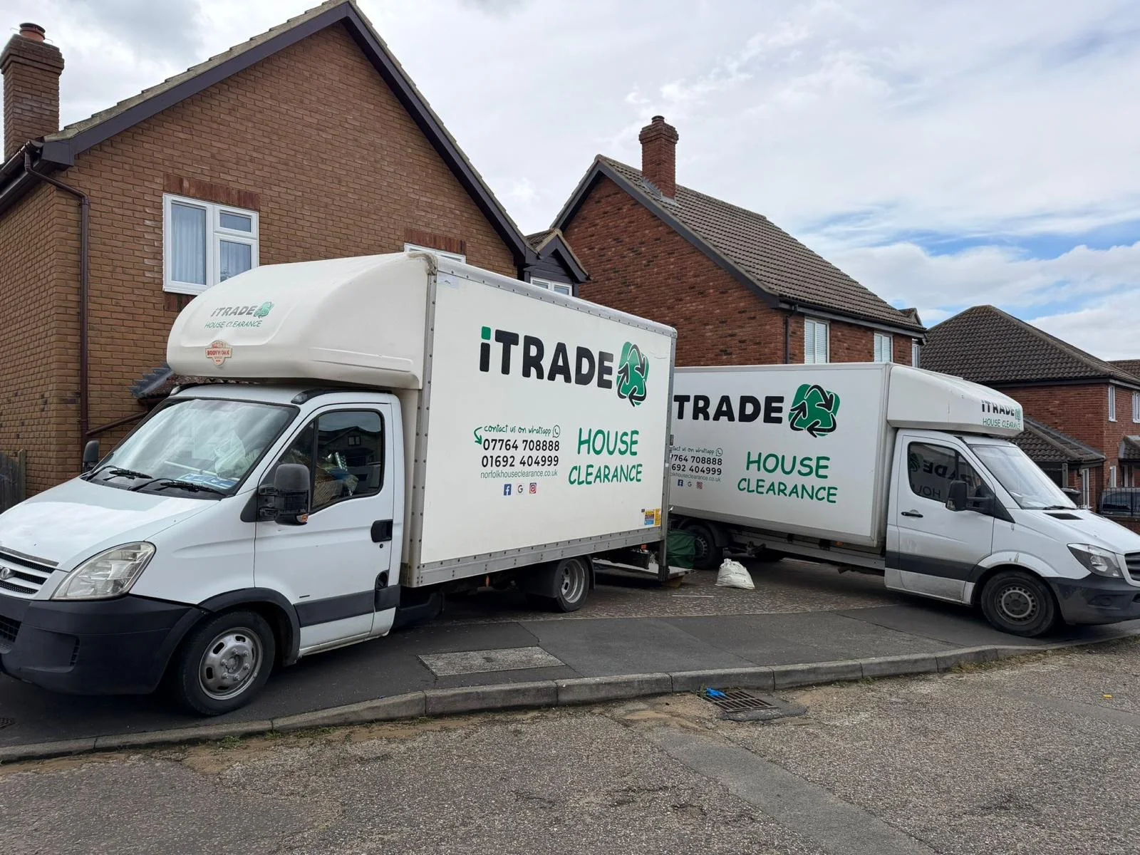 Two iTrade house-clearance vehicles outside residential houses