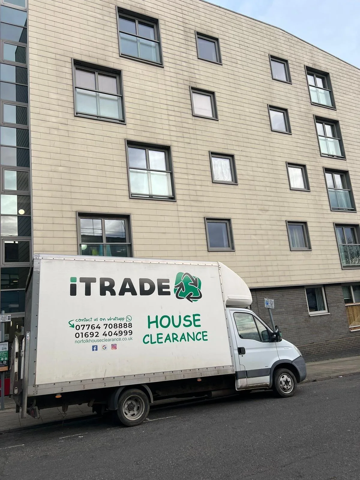 iTrade clearance vehicle outside a multi-storey residential building